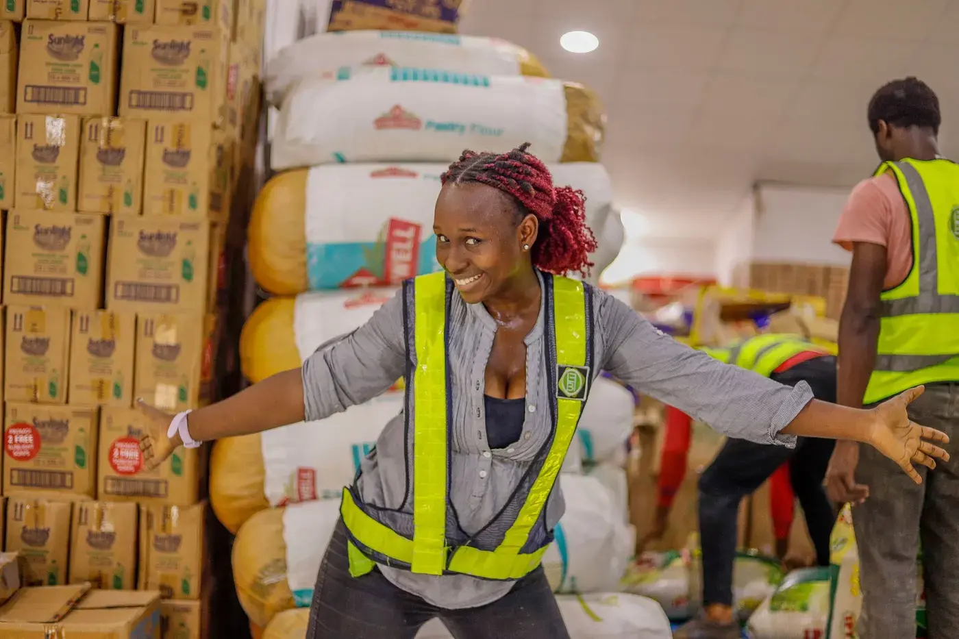 Warehouse worker in a high visibility vest checking stock on the racks